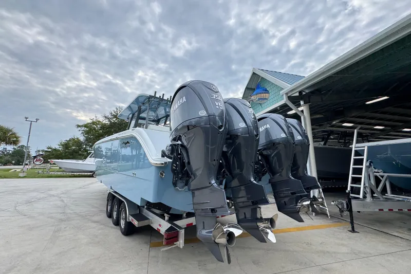 Slide: The Image of 2026 Invincible 38 Catamaran with Yamaha engines, parked outdoors under cloudy sky. - 15