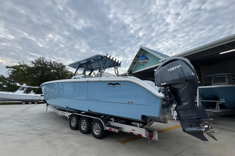 Slide: The Image of 2026 Invincible 38 Catamaran with Yamaha engine on trailer, under cloudy sky. - 16