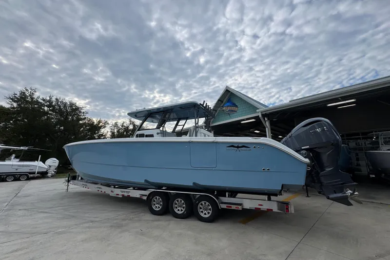 Slide: The Image of 2026 Invincible 38 Catamaran on trailer, parked outdoors under cloudy sky. - 17