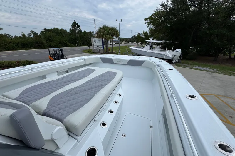 Slide: The Image of 2026 Invincible 38 Catamaran with spacious deck and cushioned seating, parked outdoors. - 18