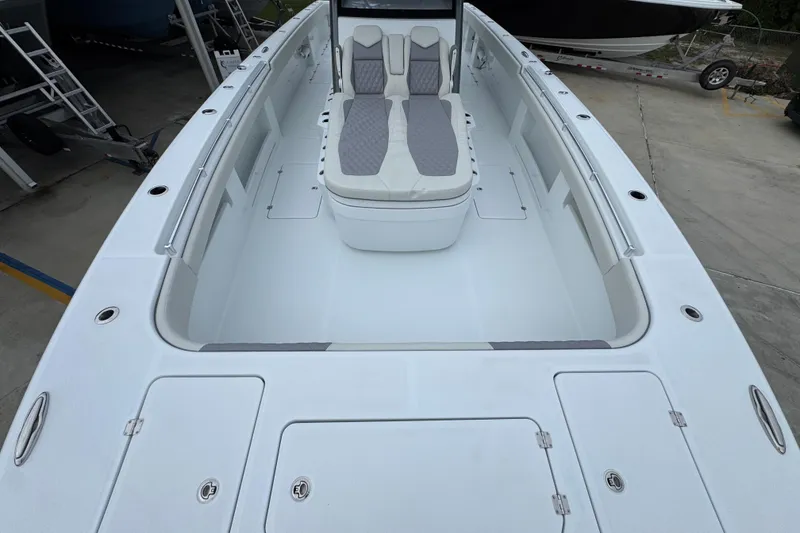 Slide: The Image of 2026 Invincible 38 Catamaran with spacious deck and seating, docked in a marina. - 21