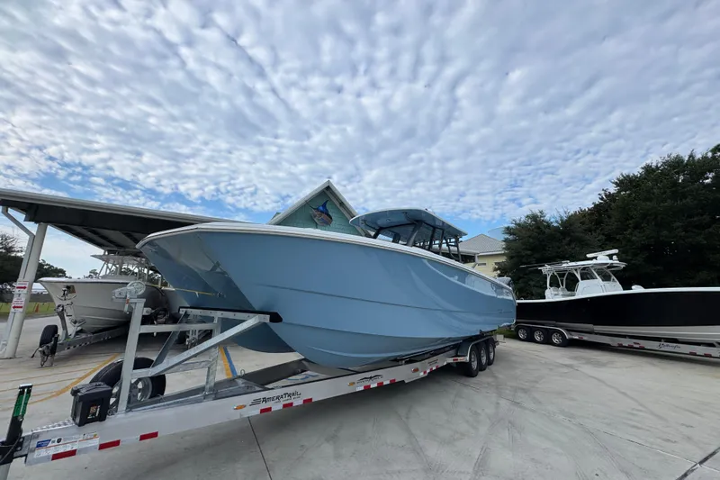 Slide: The Image of 2026 Invincible 38 Catamaran on trailer under cloudy sky. - 4