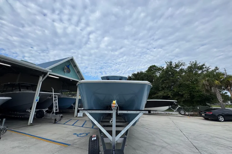 Slide: The Image of 2026 Invincible 38 Catamaran on trailer under cloudy sky at a boatyard. - 6