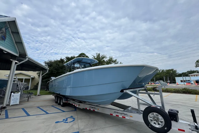 Slide: The Image of 2026 Invincible 38 Catamaran on trailer, parked outdoors under cloudy sky. - 8
