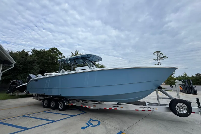 Slide: The Image of 2026 Invincible 38 Catamaran on trailer, light blue hull, parked outdoors. - 9