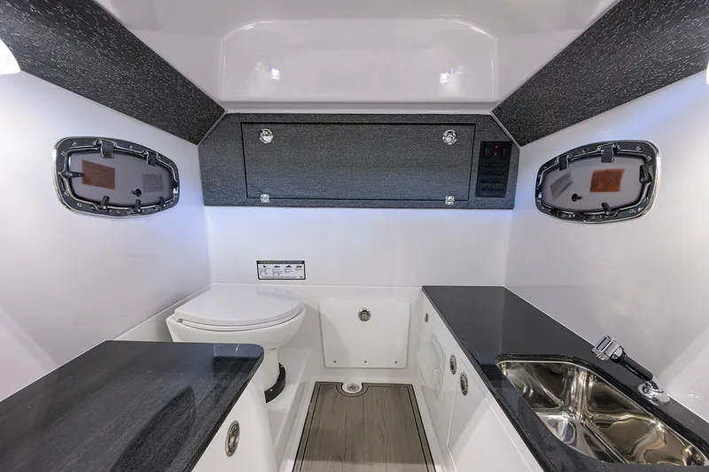 Slide: The Image of 2026 Monterey Elite 25 OB boat interior with modern bathroom and sleek design. - 11
