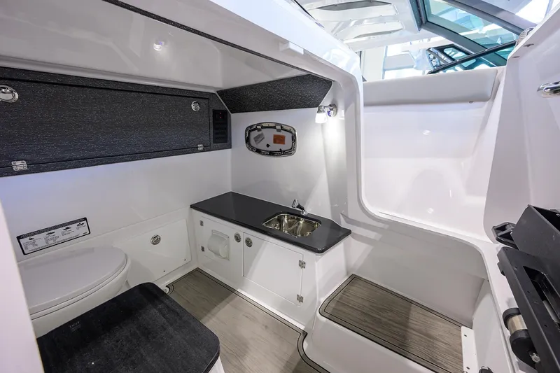 Slide: The Image of 2026 Monterey Elite 25 OB boat interior with sink, toilet, and storage. - 13