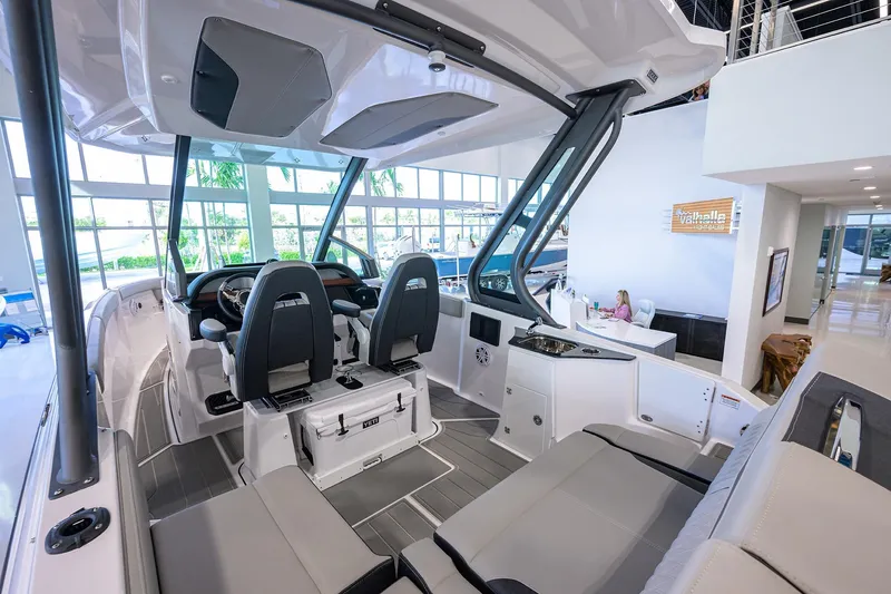 Slide: The Image of 2026 Monterey Elite 25 OB boat interior with modern seating and helm in showroom. - 18