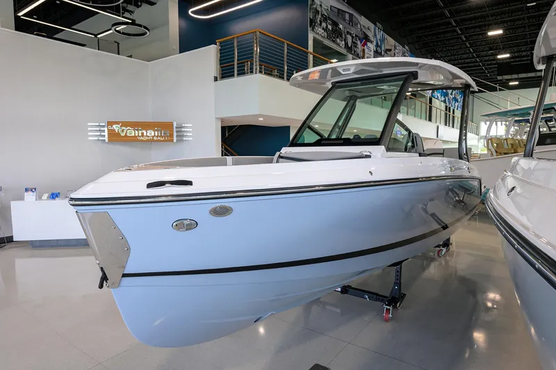 Slide: The Image of 2026 Monterey Elite 25 OB boat displayed in a modern showroom. - 2