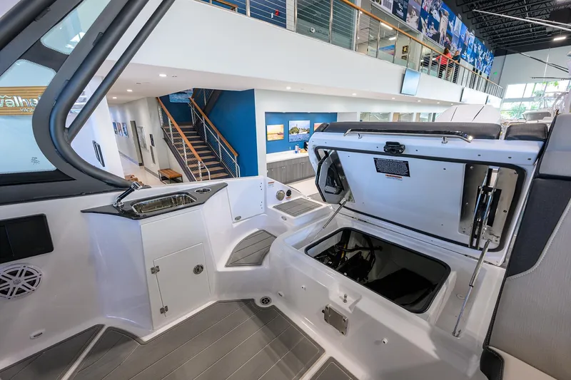 Slide: The Image of 2026 Monterey Elite 25 OB boat interior with open storage compartment in showroom. - 27