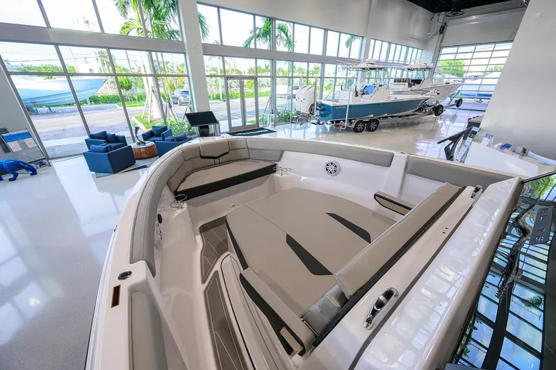 Slide: The Image of 2026 Monterey Elite 25 OB boat interior in a showroom with large windows. - 6