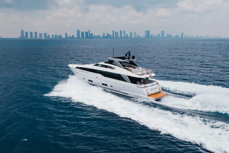 Slide: The Image of 2024 Sanlorenzo SL90A yacht cruising on open sea with city skyline in background. - 10