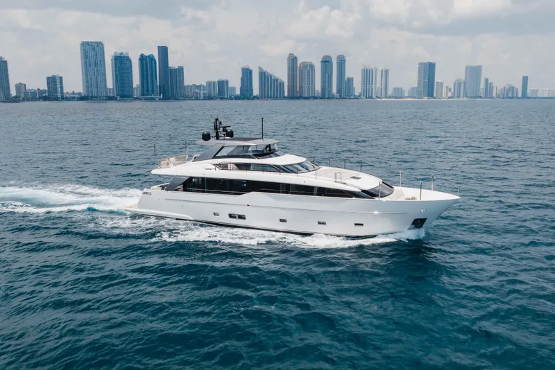 Slide: The Image of Luxury 2024 Sanlorenzo SL90A yacht cruising near city skyline on open water. - 6