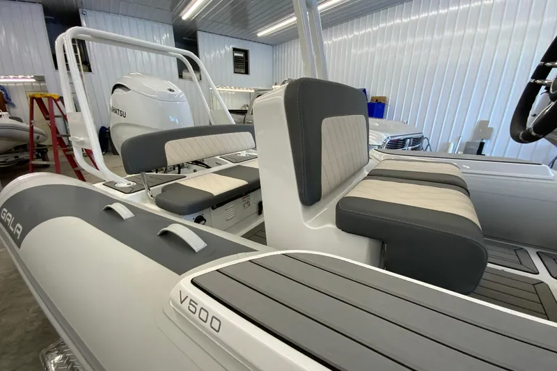 Slide: The Image of 2026 Gala V500 boat interior with gray and white seating in a showroom. - 10