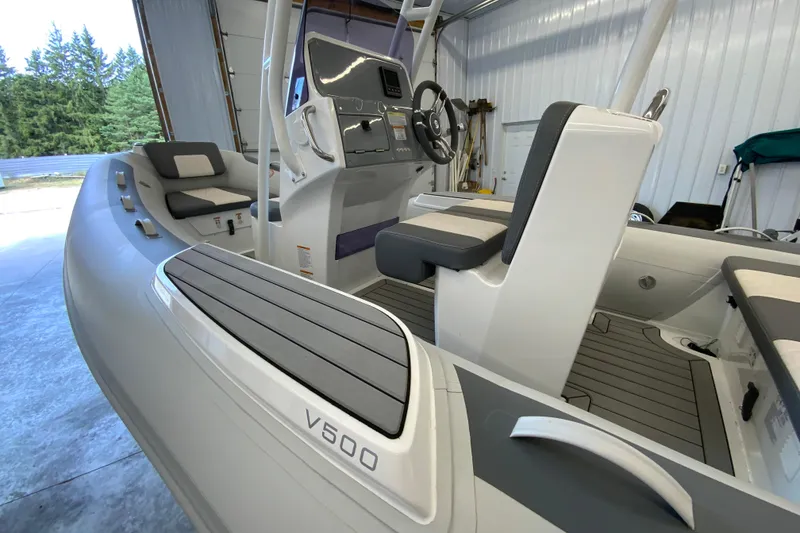 Slide: The Image of 2026 Gala V500 boat interior with modern seating and steering console in a garage setting. - 4