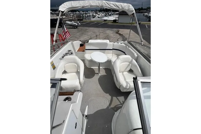 Slide: The Image of 2006 Formula 240 Bowrider boat interior with white seating and table, docked at marina. - 10