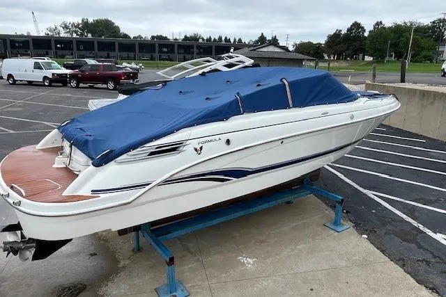 Slide: The Image of 2006 Formula 240 Bowrider boat with blue cover in a parking lot. - 24