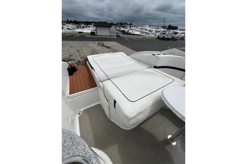 Slide: The Image of 2006 Formula 240 Bowrider boat interior with white seating and table, docked at marina. - 7