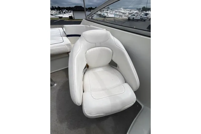 Slide: The Image of White seat on 2006 Formula 240 Bowrider boat, docked with other boats visible. - 8