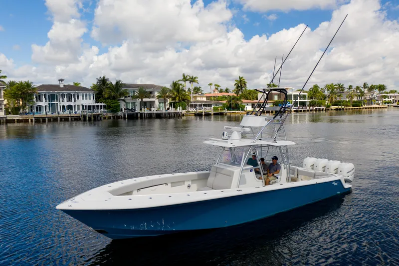 The Image of 2021 SeaVee 390Z boat cruising on a scenic waterfront with luxury homes. - 0