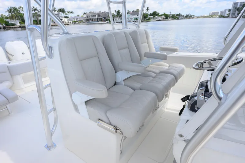 Slide: The Image of 2021 SeaVee 390Z boat interior with luxurious seating and steering wheel, overlooking waterfront homes. - 9