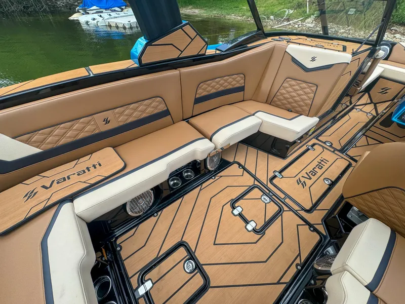 Slide: The Image of 2024 Varatti Z2373 boat interior with tan and black seating, custom flooring, and lake backdrop. - 28