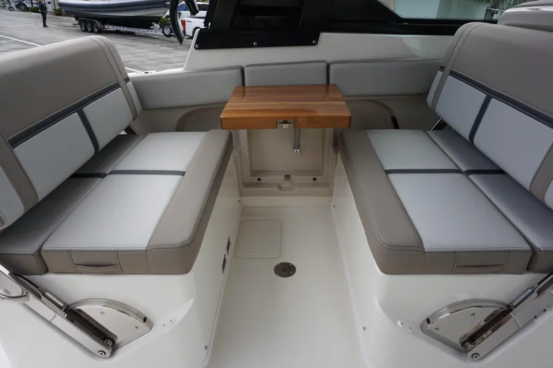 Slide: The Image of 2026 Boston Whaler 330 Vantage interior seating with foldable table, showcasing luxury design. - 19