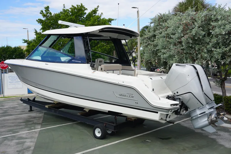 Slide: The Image of 2026 Boston Whaler 330 Vantage boat on display, featuring sleek design and powerful outboard engines. - 2