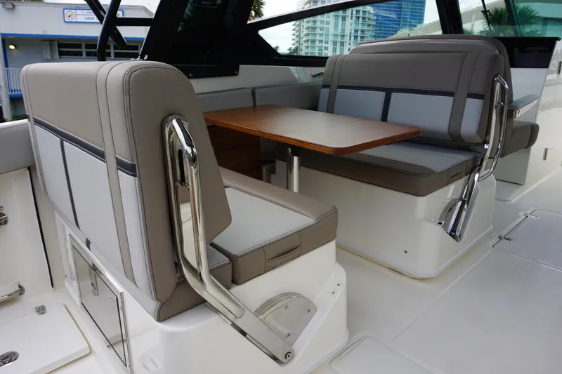 Slide: The Image of 2026 Boston Whaler 330 Vantage interior seating with table, showcasing luxury and comfort. - 21