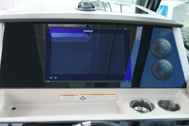 Slide: The Image of 2026 Boston Whaler 330 Vantage dashboard with Simrad display and cup holders. - 29
