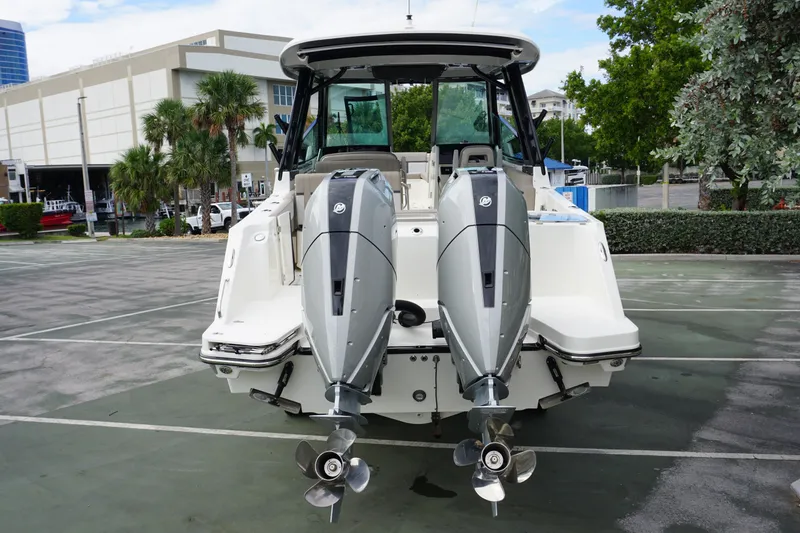 Slide: The Image of 2026 Boston Whaler 330 Vantage with dual outboard engines, parked outdoors. - 3