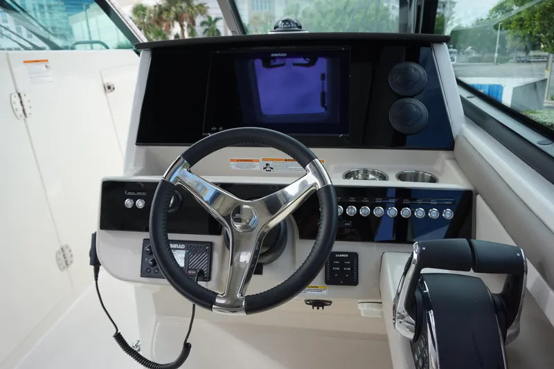 Slide: The Image of 2026 Boston Whaler 330 Vantage helm with steering wheel and control panel. - 30