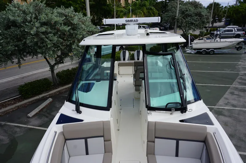 Slide: The Image of 2026 Boston Whaler 330 Vantage boat with spacious seating and modern design in a parking lot. - 39