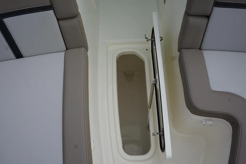 Slide: The Image of Open storage compartment on 2026 Boston Whaler 330 Vantage boat, between cushioned seats. - 42