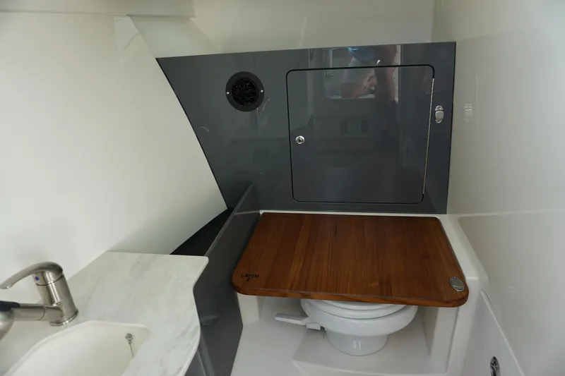 Slide: The Image of 2026 Boston Whaler 330 Vantage boat interior with sink and wooden toilet cover. - 46