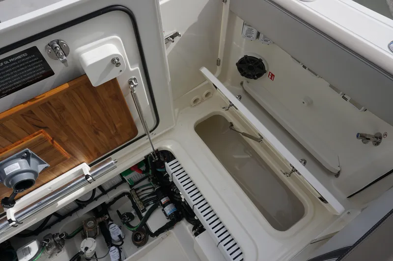 Slide: The Image of 2026 Boston Whaler 330 Vantage boat interior showing storage and mechanical components. - 52