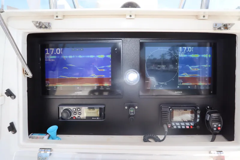 Slide: The Image of 2008 Contender 31 Tournament boat dashboard with Garmin navigation displays and communication equipment. - 19