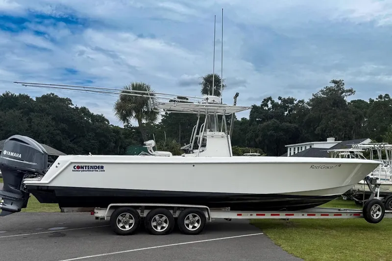 Slide: The Image of 2008 Contender 31 Tournament boat on trailer, featuring Yamaha engines, parked outdoors. - 33