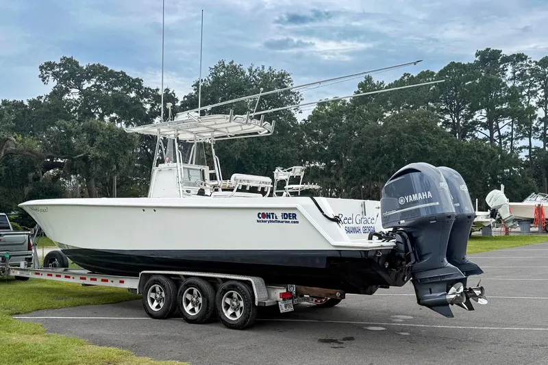 Slide: The Image of 2008 Contender 31 Tournament boat on trailer with dual Yamaha engines, parked outdoors. - 38