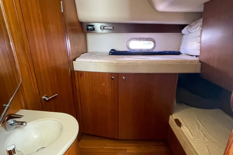 Slide: The Image of 2005 Tiara Yachts 4400 Sovran cabin interior with wooden finish and compact sink. - 10