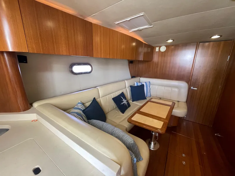 Slide: The Image of 2005 Tiara Yachts 4400 Sovran interior with plush seating and wooden accents. - 13