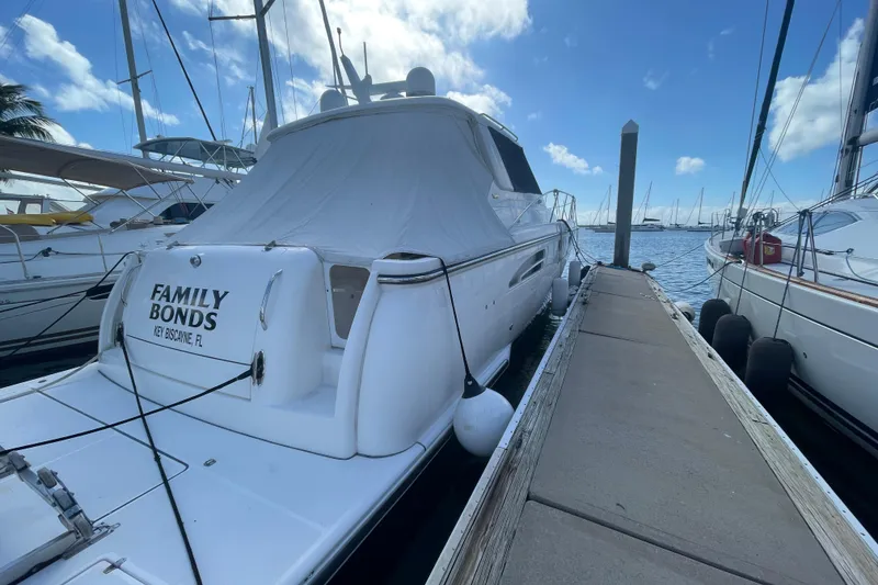 Slide: The Image of 2005 Tiara Yachts 4400 Sovran docked at marina under blue sky. - 3