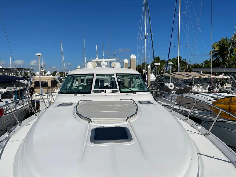 Slide: The Image of 2005 Tiara Yachts 4400 Sovran docked at a marina under clear blue skies. - 4