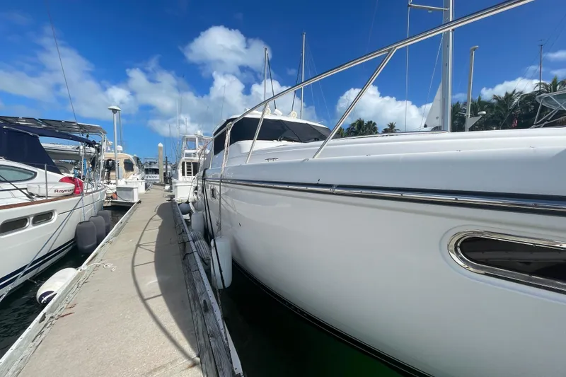 Slide: The Image of 2005 Tiara Yachts 4400 Sovran docked at marina under clear blue sky. - 5