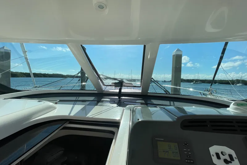 Slide: The Image of 2005 Tiara Yachts 4400 Sovran helm view with marina backdrop. - 6