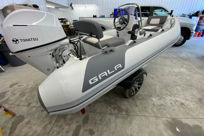 Slide: The Image of 2026 Gala A330L inflatable boat with Tohatsu engine in a garage setting. - 12