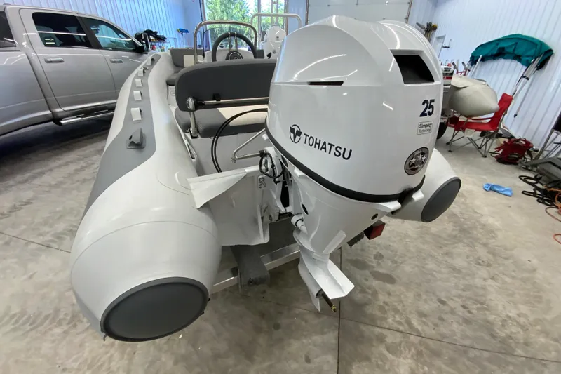 Slide: The Image of Inflatable boat Gala A330L 2026 with Tohatsu outboard motor in a garage setting. - 3