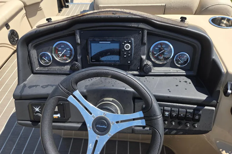 Slide: The Image of 2023 Bentley Pontoons Legacy Cruise dashboard with steering wheel and gauges. - 10