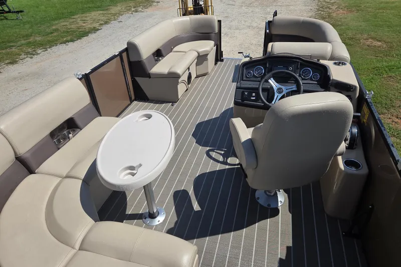 Slide: The Image of 2023 Bentley Pontoons Legacy Cruise interior with beige seating and steering console. - 11
