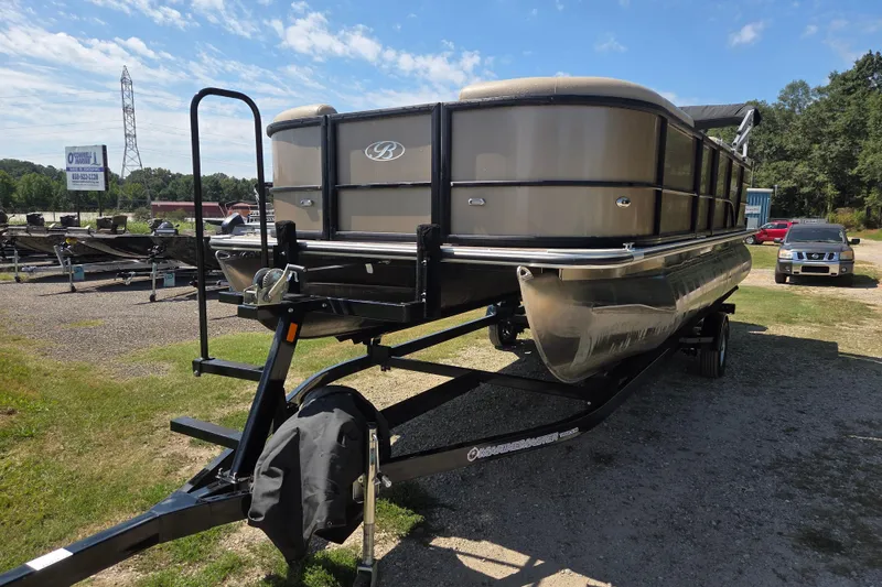 Slide: The Image of 2023 Bentley Pontoons Legacy Cruise on trailer, parked outdoors under a clear sky. - 2